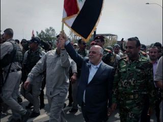 قدم زدن العبادی با پرچم عراق در خیابان‌های تکریت - عکس