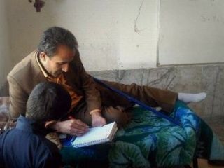 معلم یاسوجی روی تخت در کلاس تدریس می‌کند