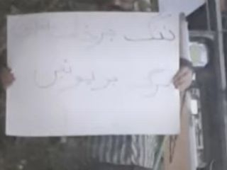 اعتراض مردی تنها با پلاکاردی که روی آن نوشته «ننگ بر خامنه ای، مرگ بر پوتین