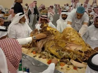 سرو و بُرش زدن شتر بریان شده در یک مراسم عروسی عربی