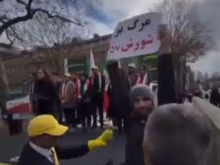 حمله هواداران مجاهدین به فرد که در سکوت پلاکارد«مرگ بر شورش ۵۷ » را بالا برده بود